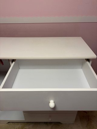 Cómoda armario blanca con puerta y cinco cajones.
