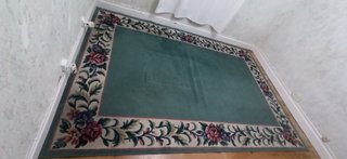 Alfombra verde con borde floral