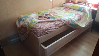 Cama individual de madera con cama anidada.