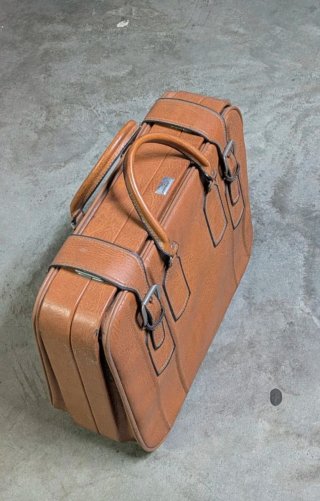 Maleta vintage de cuero marrón.