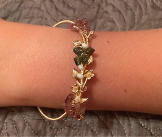 Pulsera dorada con flores y piedras