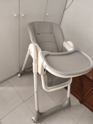 Trona de bebé plegable gris y cuna blanca