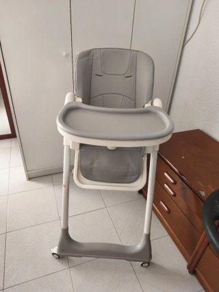 Trona de bebé plegable gris y cuna blanca