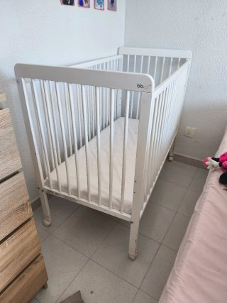 Trona de bebé plegable gris y cuna blanca