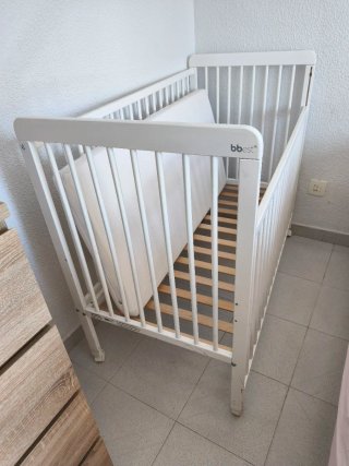 Trona de bebé plegable gris y cuna blanca