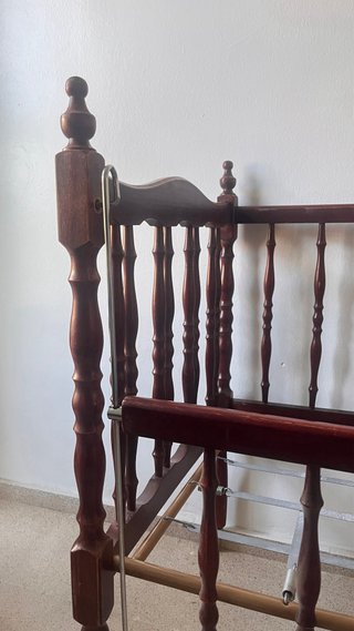 Cuna de bebé de madera oscura con ruedas