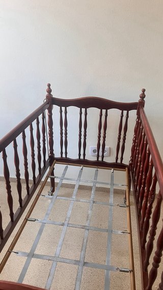Cuna de bebé de madera oscura con ruedas