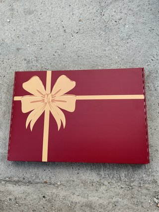 Caja de regalo roja con lazo dorado