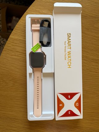Smartwatch rosa con cargador y manual