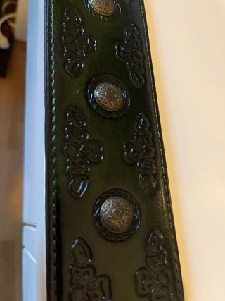 Cinturón de guitarra negro con hebilla dorada