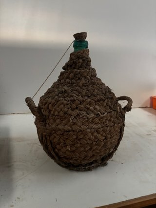 Botella de vidrio con cesta de mimbre