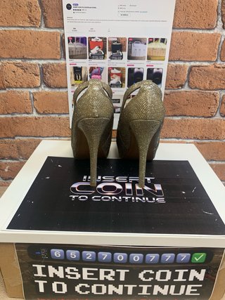 Zapatos de tacón dorados de exposición