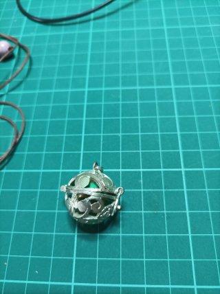 Llamador de ángeles plateado con detalles verdes