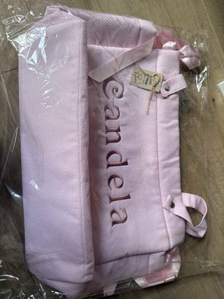 Bolso de bebe con nombre grabado en color rosa.