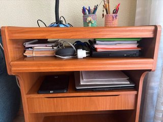 Mueble de TV de madera con estante.