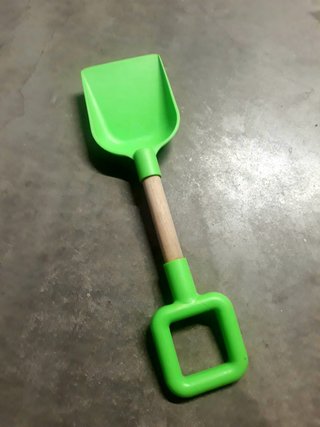 Pala de playa verde con mango de madera