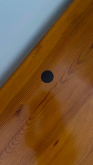 Mesa baja de madera color miel, con pequeña mancha