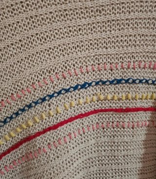 Poncho bege com franjas e detalhes coloridos