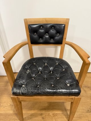Silla vintage de madera y piel negra.