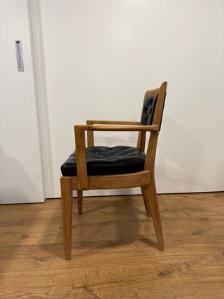 Silla vintage de madera y piel negra.