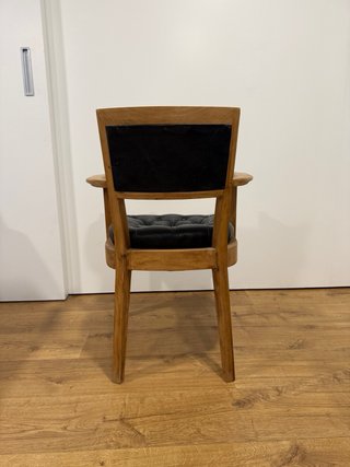 Silla vintage de madera y piel negra.