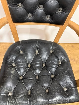Silla vintage de madera y piel negra.