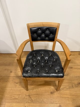 Silla vintage de madera y piel negra.