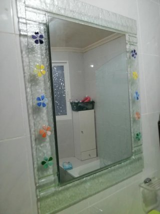 Espejo de baño decorado con flores y accesorios