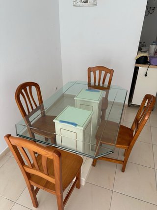 Una mesa de comedor con tapa de cristal y 4 sillas