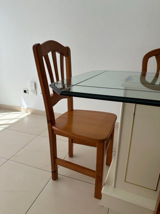 Una mesa de comedor con tapa de cristal y 4 sillas