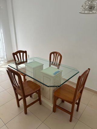 Una mesa de comedor con tapa de cristal y 4 sillas