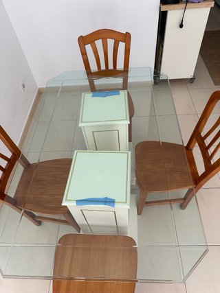 Una mesa de comedor con tapa de cristal y 4 sillas