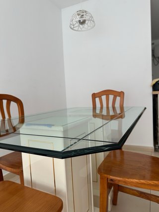 Una mesa de comedor con tapa de cristal y 4 sillas
