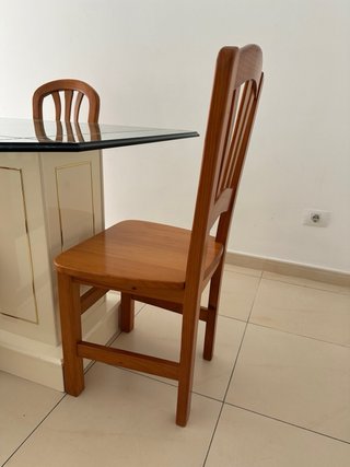 Una mesa de comedor con tapa de cristal y 4 sillas