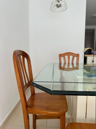 Una mesa de comedor con tapa de cristal y 4 sillas