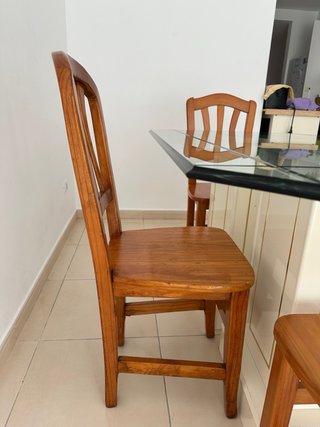 Una mesa de comedor con tapa de cristal y 4 sillas