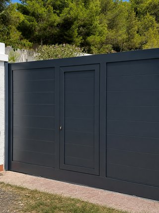 Puerta corredera de aluminio con puerta peatonal