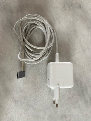 cargador es un Apple MagSafe 3 oficial con enchufe