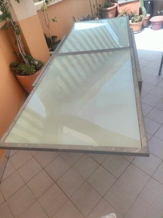 Mesa metálica con sobre de cristal.