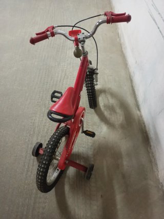 Bicicleta infantil roja con ruedines