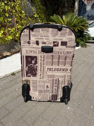 Maleta de viaje con estampado de periódico
