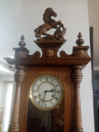 Reloj de madera antiguo con figura de caballo