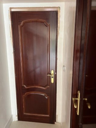 Puerta de madera oscura con pomo dorado