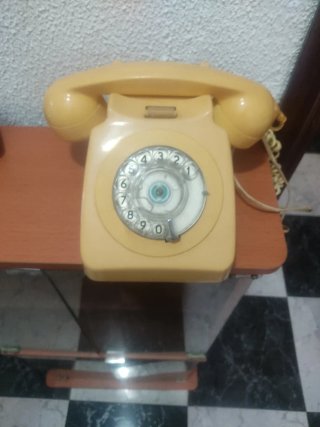 Teléfono antiguo de disco amarillo