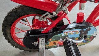 Bicicleta infantil roja con ruedines