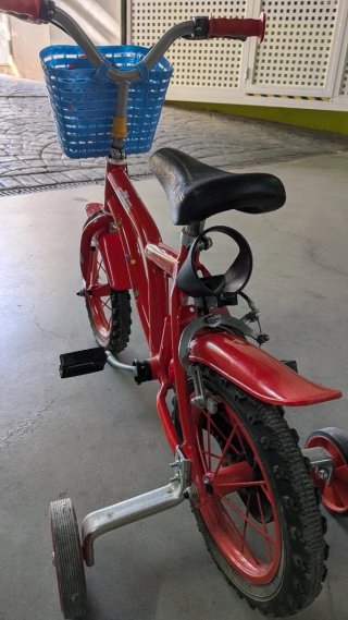 Bicicleta infantil roja con ruedines