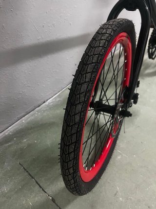 Bicicleta infantil negra con ruedas rojas, sin uso
