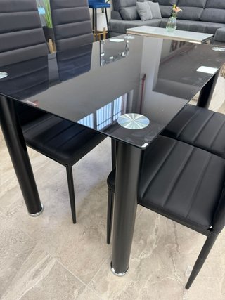 Mesa de cristal con 4 sillas negras