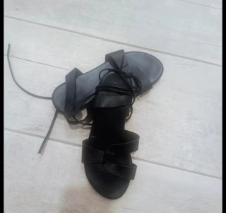 Sandalias planas negras atadas al tobillo