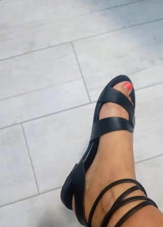 Sandalias planas negras atadas al tobillo